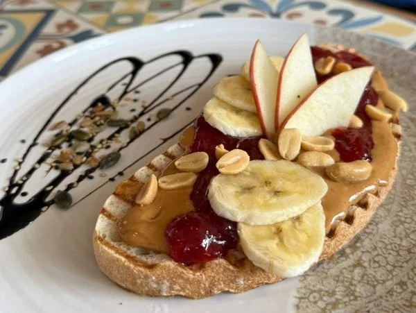 Toast avec banane, cacahuètes, confiture et pomme — origine externe à vérifier