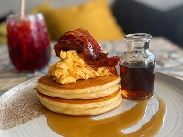 Pancakes avec œufs brouillés, bacon et sirop — origine externe à vérifier